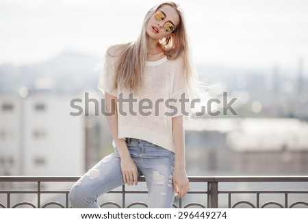 Fashion model. Summer look. Jeans, sweater, sunglasses.