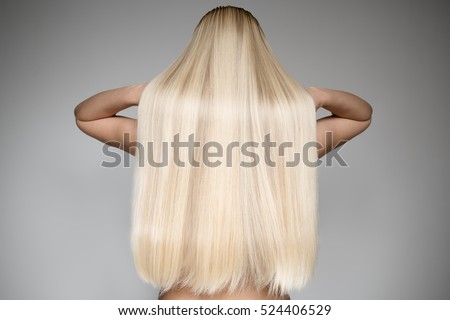 Portrait Of A Beautiful Young Blond Woman With Long Straight Hair. Back View
