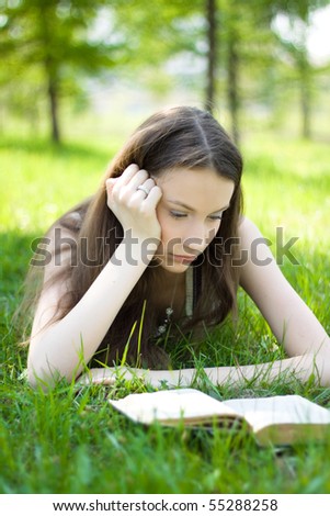 Young student reading book in park