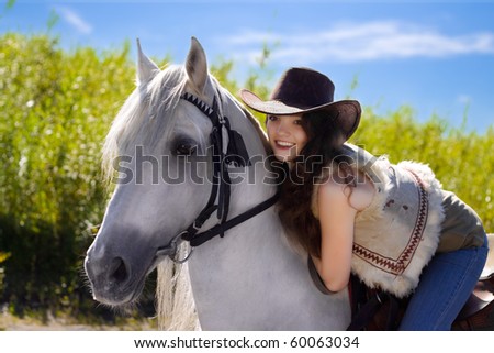 young cowgirl on white horse smile