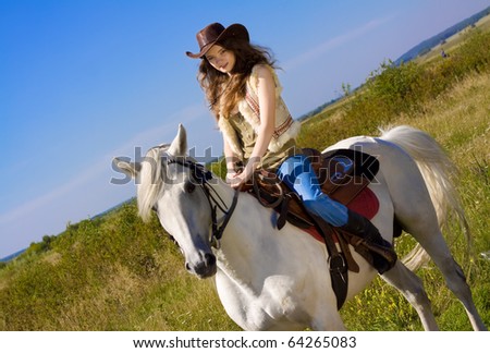 young cowgirl on white horse