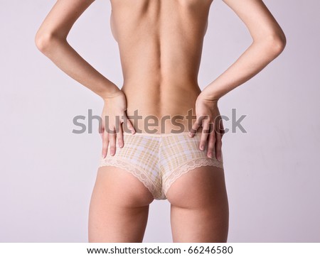 beauty girl back in pants over gray background