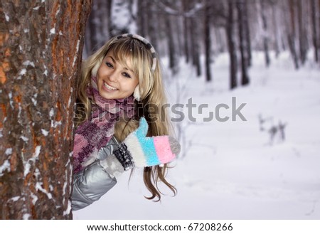pretty young woman thumbs-up in winter forest