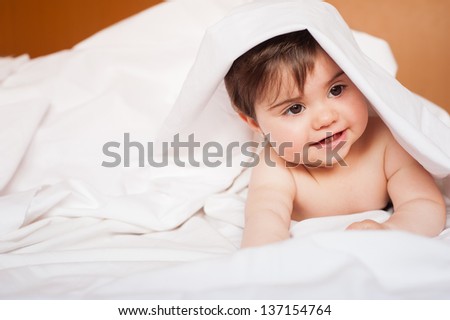 Cute baby under bed sheet