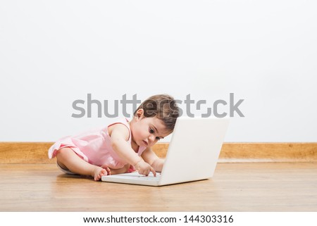 Cute baby pushing a keyboard on a floor