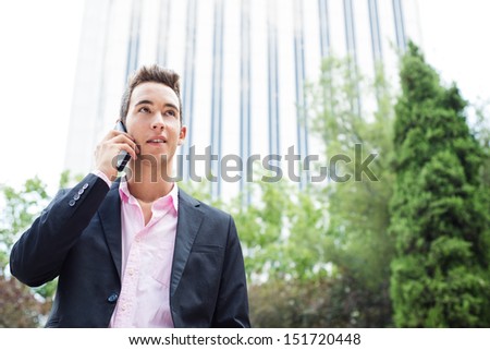 Young entrepreneur with his phone talking and looking into the negative space