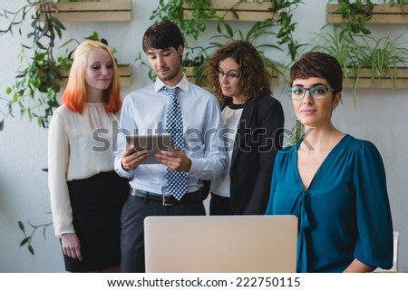 Team of four person working, focus on girl with laptop