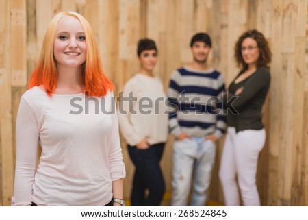Young student smiling with group of three mates in the background