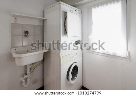 Laundry with washer and dryer stacked on top of each other.