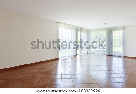 room with terracotta floor,windows with white curtains