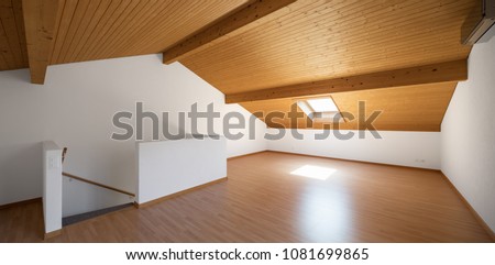 Large attic with wooden floors and exposed beams. White walls, perfect for copy-sace