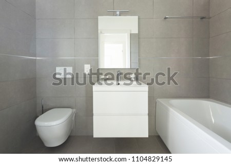 Modern bathroom with large tiles in newly built apartment. Nobody inside