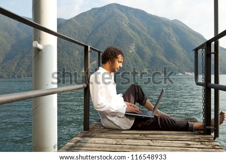 portrait of young man on the dock of lake