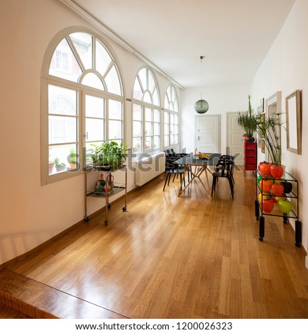 Dining room in renovated design apartment. Large arched windows.
