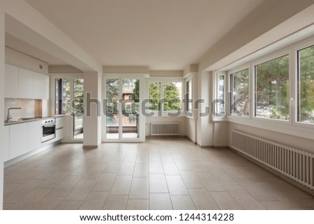 Open space with large windows and modern kitchen. Nobody inside