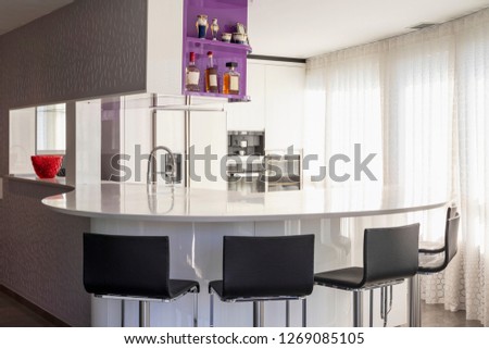 Kitchen with purple and white wardrobe, black counter. Elegant and minimalist. Nobody inside