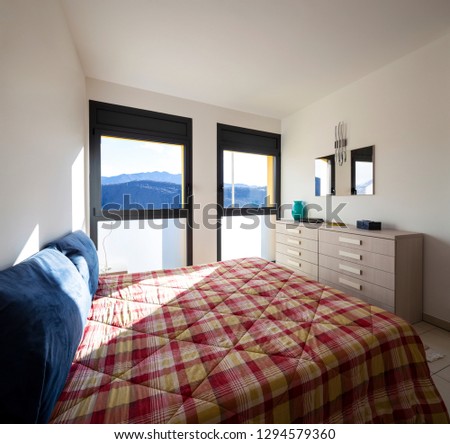 Bright bedroom with window overlooking the mountains. Nobody inside