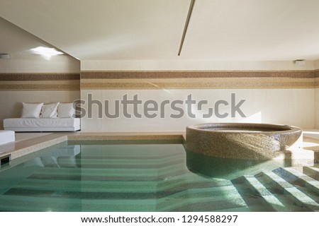 Indoor pool of private villa with lake view and bar area. Nobody inside