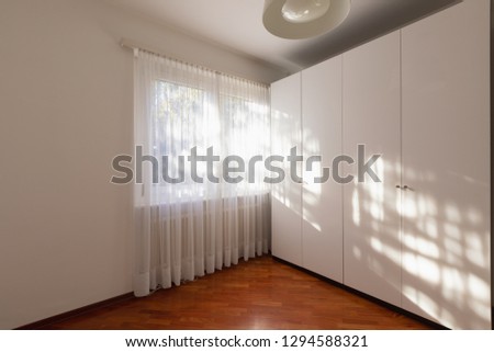 Empty room with window, curtain and parquet. Nobody inside
