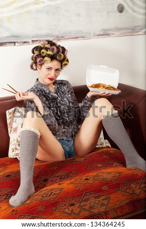 sexy girl eating spaghetti on the couch