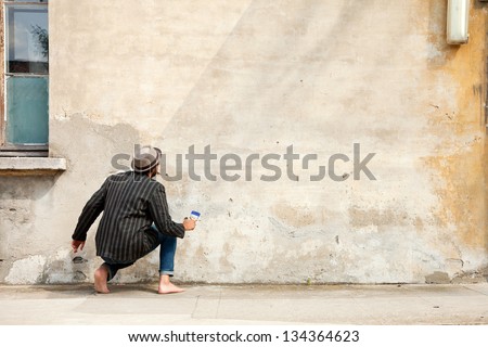man from behind, writes on a wall