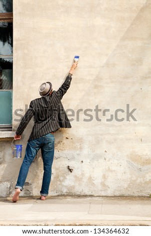 man from behind, writes on a wall
