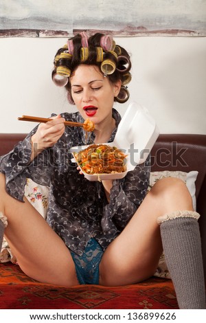sexy girl eating spaghetti on the couch
