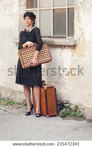 Woman waiting in the street with luggage