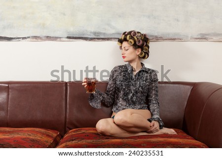 portrait of fashion model sitting on the sofa with a cocktail