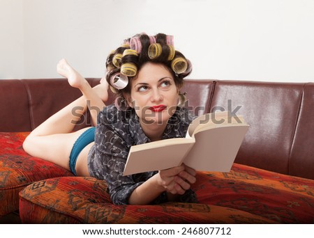 portrait of a model with a book, lying on the sofa