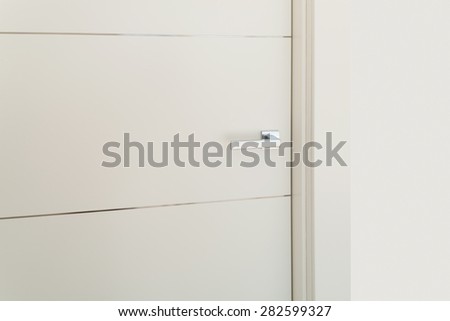 Interior modern house, detail of a door with steel handle