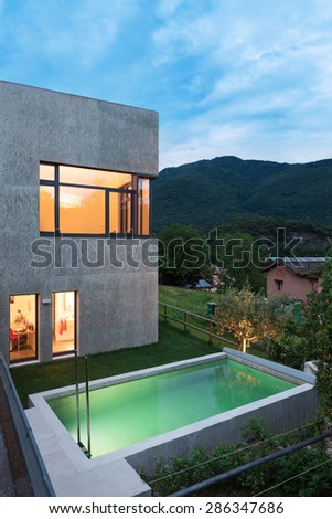external of a modern house with pool, night scene