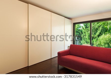 Interior of modern house, room with closets and red divan