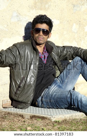 portrait of cool young man leaning on wall outdoors
