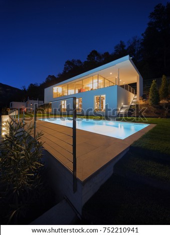 Modern house, exterior in the night, lights on