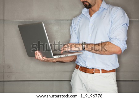 Man in office checking his presentation on laptop - landscape interior