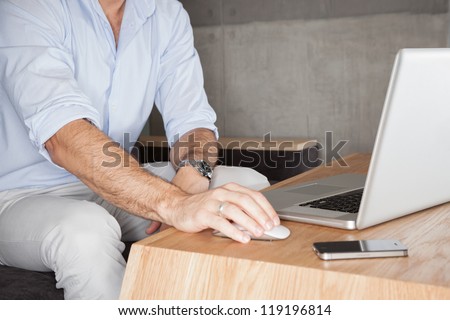 Man in office with laptop - landscape interior.