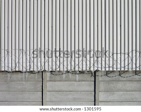 Landscape photo of industrial barbed-wire security wall.