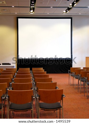 Portrait photo of blank conference room projector screen from audience.
