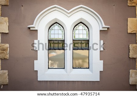 Old style church windows in brown wall - landscape exterior