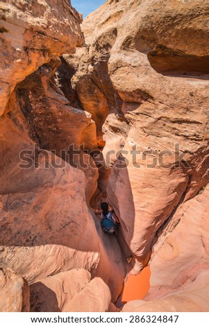Girl Hiker Backpacker Climbing down the Slot Canyon