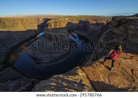Girl Hiker Standing at the edge of Horseshoe Bend Page Arizona Sunrise