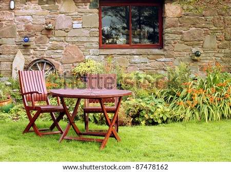 Quaint Table and Chairs in Vibrant Garden of Rustic Country Cottage