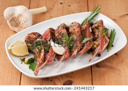 prepared to grill raw lamb chops with a sprig of rosemary