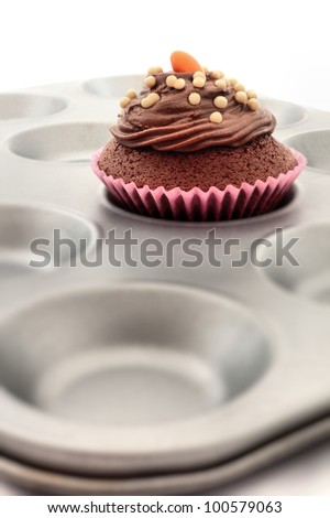 Homemade chocolate cupcake, or fairy cake, with buttercream in a baking tray.