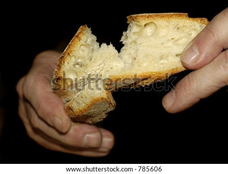 Hands tear at a piece of sourdough bread (Hands soft focus)