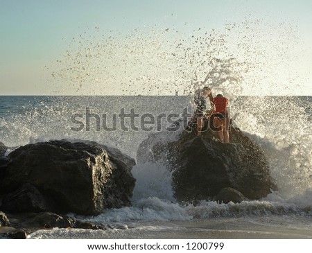 Couple braves the crashing waves at a California beach