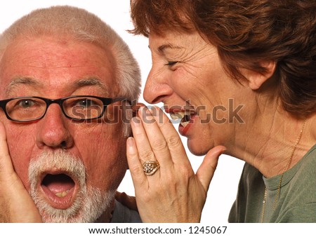 Woman laughs and whispers into husband's ear