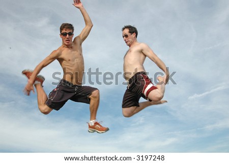 two guys jump into air goofing around