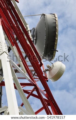 Telecommunication tower with cell phone antenna system against blue sky